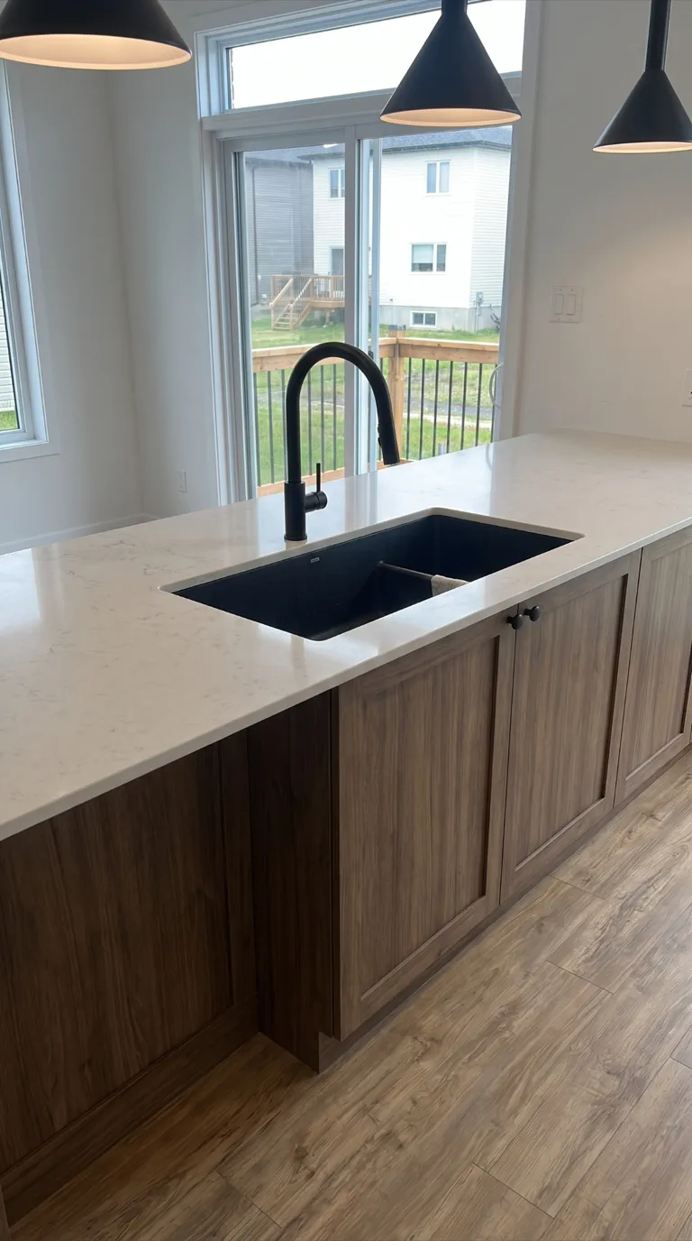 Îlot de quartz veiné avec évier noir et robinetterie noir mat, tourné vers la porte-patio